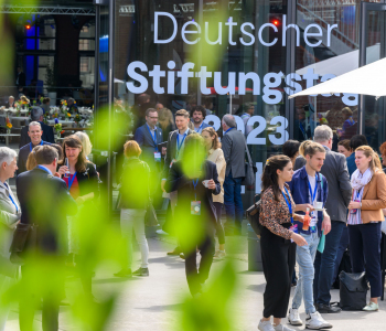 Eine Menschenmenge steht um ein großes Schild, auf dem Deutscher Stiftungstag 2023 Berlin steht. 2023 und Berlin sind teilweise verdeckt.