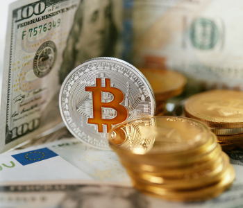 Nahaufnahme von Dollarscheinen und einer Bitcoin-Münze