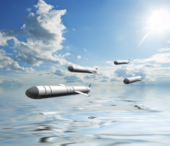 Raketen fliegen über Wasser vor Wolke und Sonnenhimmel. 