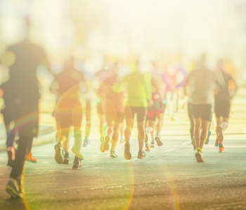 Marathon-Läufer vor Sonnenlicht auf Straße.