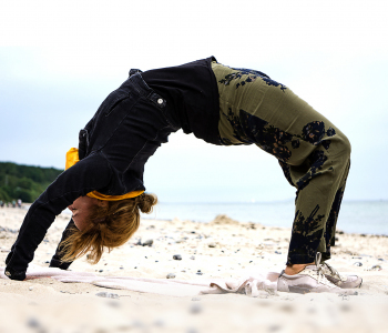 Junge Frau macht Yoga am Strand.