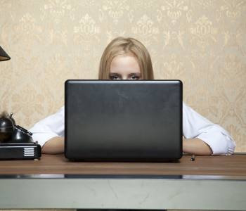 Eine Business-Frau versteckt sich hinter einem Laptop