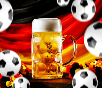 Fußbälle und ein kühles Bier vor deutscher Flagge