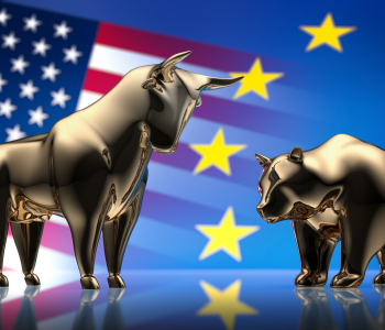 Die Börsensymbole Bulle und Bär vor einer europäischen und einer US-Flagge