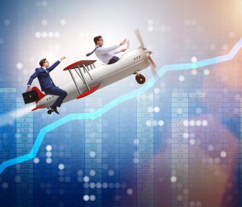 Zwei Geschäftsmänner fliegen in einem alten Doppeldecker-Flugzeug vor einem grafisch dargestellten Aktien-Kursverlauf