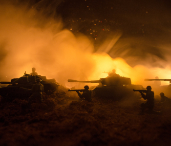 Panzer und Soldaten im Gelände bei Nacht.