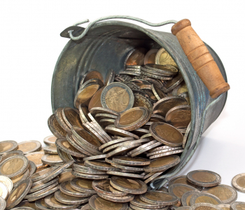 Euro-Münzen werden aus einem Eimer gekippt.
