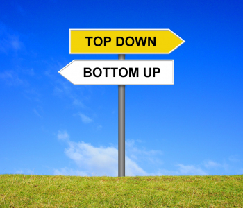 Zwei Schilder zeigen in entgegengesetzte Richtung. Aufschrift: TOP DOWN und BOTTOM UP